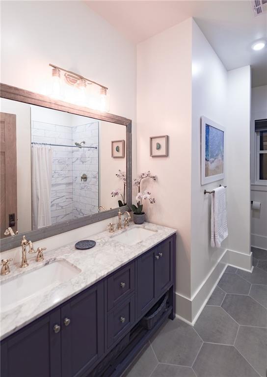 623-25 Louisa St, New Orleans, LA 70117 - bathroom with double vanity, a tile shower, and tile patterned floors