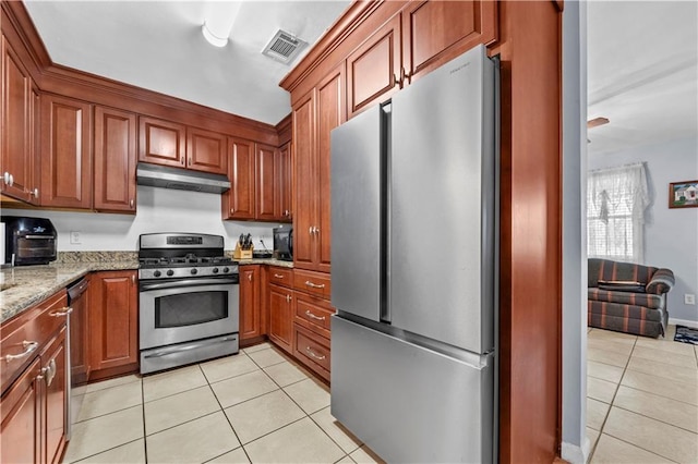 603 E Manley Ave, Metairie, LA 70001 - kitchen featuring stainless steel appliances, light tile patterned floors, under cabinet range hood, light stone countertops, and brown cabinetry