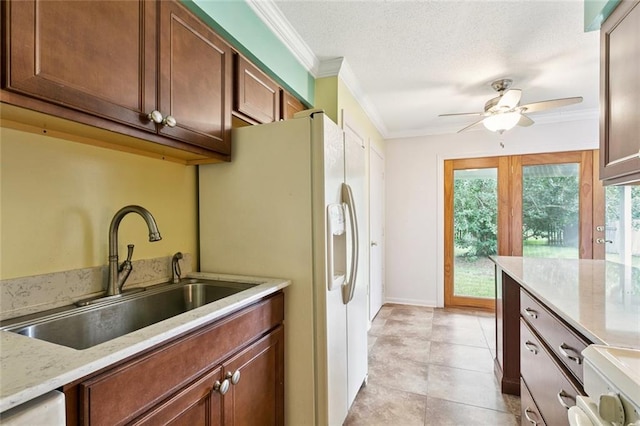 230 Brett Dr, Gretna, LA 70056 - kitchen featuring crown molding, white fridge with ice dispenser, ceiling fan, a textured ceiling, and light stone counters