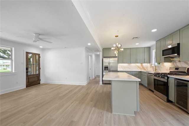 8853 26th St, Metairie, LA 70003 - kitchen with appliances with stainless steel finishes, green cabinets, wine cooler, backsplash, and recessed lighting
