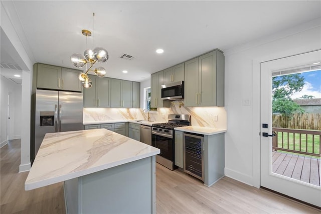 8853 26th St, Metairie, LA 70003 - kitchen featuring gray cabinetry, appliances with stainless steel finishes, light stone countertops, wine cooler, and decorative backsplash