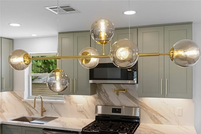 8853 26th St, Metairie, LA 70003 - detailed view of appliances with stainless steel finishes, tasteful backsplash, gray cabinets, light stone countertops, and pot filler