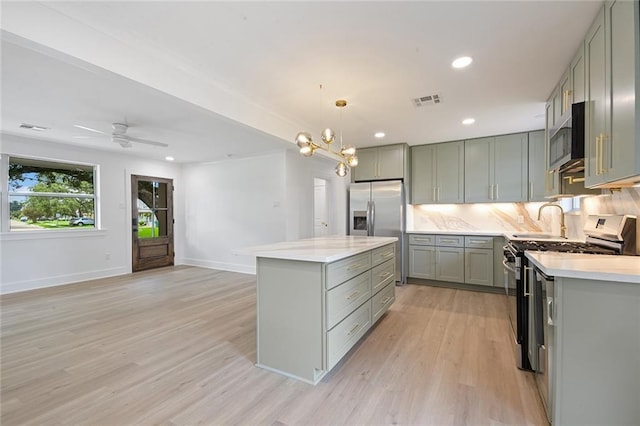 8853 26th St, Metairie, LA 70003 - kitchen with gray cabinets, stainless steel appliances, light countertops, light wood-type flooring, and recessed lighting