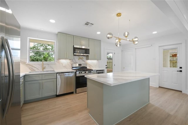 8853 26th St, Metairie, LA 70003 - kitchen with stainless steel appliances, gray cabinets, light wood-style floors, decorative backsplash, and recessed lighting