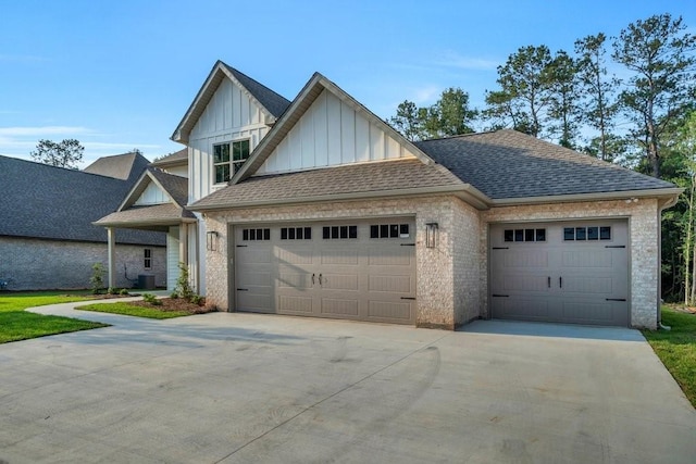 5053 Twin River Pl, Covington, LA 70433 - view of front facade featuring board and batten siding, concrete driveway, an attached garage, a shingled roof, and brick siding