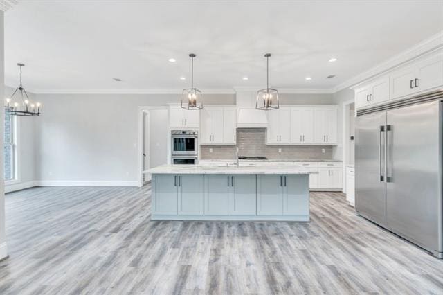 5053 Twin River Pl, Covington, LA 70433 - kitchen featuring stainless steel appliances, a chandelier, light countertops, decorative backsplash, and crown molding