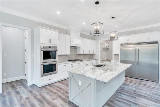 5053 Twin River Pl, Covington, LA 70433 - kitchen with stainless steel appliances, crown molding, white cabinets, an island with sink, and recessed lighting