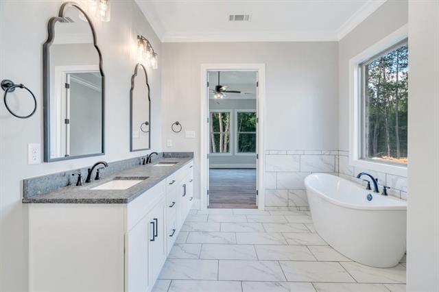 5053 Twin River Pl, Covington, LA 70433 - full bathroom with marble finish floors, a freestanding bath, double vanity, ceiling fan, and crown molding