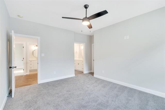 5053 Twin River Pl, Covington, LA 70433 - unfurnished bedroom with light colored carpet, ensuite bath, and ceiling fan