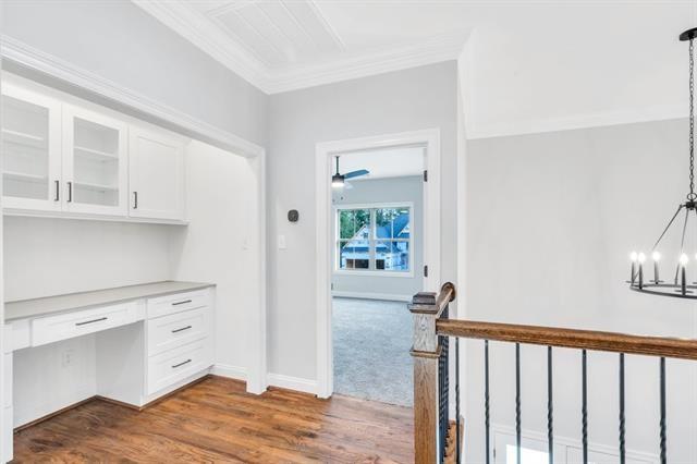 5053 Twin River Pl, Covington, LA 70433 - unfurnished office with built in desk, a chandelier, dark wood finished floors, and ornamental molding
