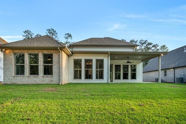 5053 Twin River Pl, Covington, LA 70433 - rear view of house featuring a ceiling fan, a yard, and brick siding