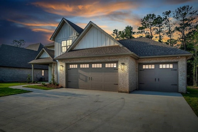 5053 Twin River Pl, Covington, LA 70433 - view of front of property with board and batten siding, driveway, an attached garage, and a shingled roof