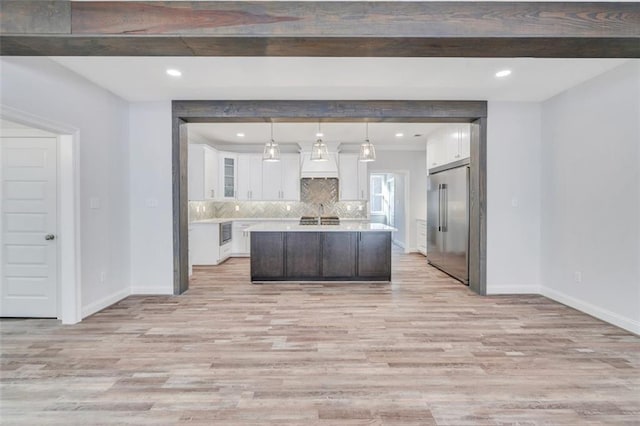 5028 Twin River Pl, Covington, LA 70433 - kitchen with appliances with stainless steel finishes, light wood finished floors, light countertops, white cabinetry, and backsplash