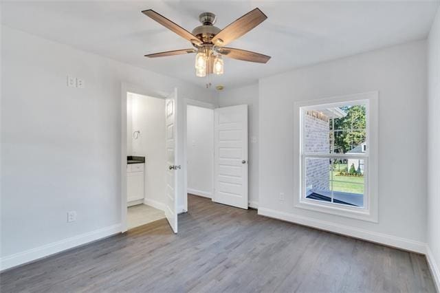 5028 Twin River Pl, Covington, LA 70433 - unfurnished bedroom featuring wood finished floors, ensuite bath, and a ceiling fan