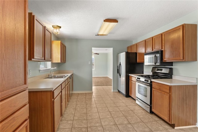 1403 W First St, Belle Chasse, LA 70037 - kitchen featuring stainless steel gas stove, black microwave, light countertops, a textured ceiling, and light tile patterned flooring