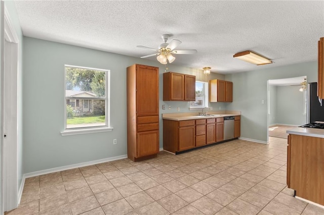 1403 W First St, Belle Chasse, LA 70037 - kitchen featuring dishwasher, a ceiling fan, light countertops, brown cabinets, and a textured ceiling