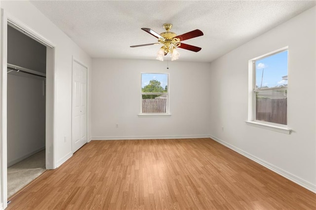 1403 W First St, Belle Chasse, LA 70037 - unfurnished bedroom with light wood-style flooring, a textured ceiling, and a ceiling fan