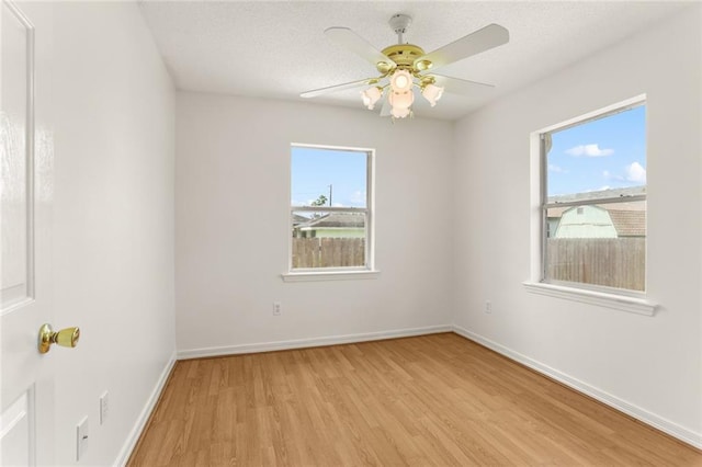 1403 W First St, Belle Chasse, LA 70037 - empty room featuring light wood-style floors, healthy amount of natural light, a ceiling fan, and a textured ceiling