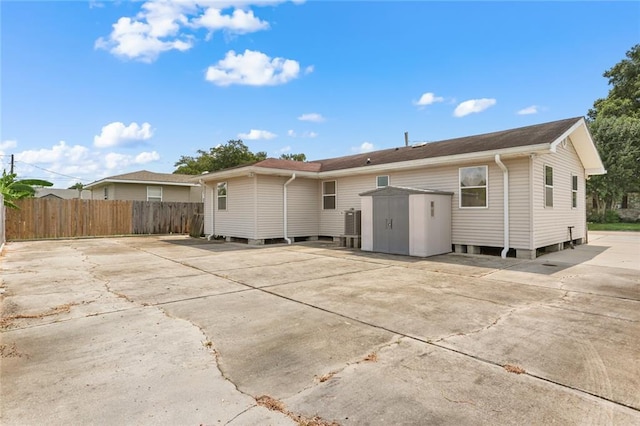 1403 W First St, Belle Chasse, LA 70037 - back of house featuring a storage unit and concrete driveway