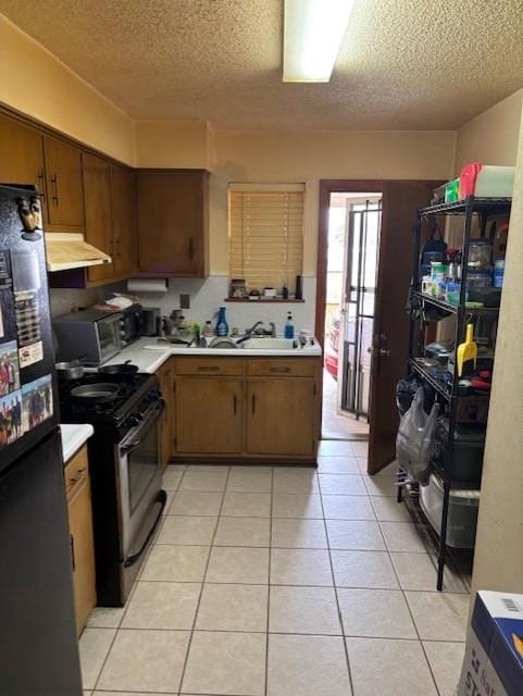 305 Lilac St, Metairie, LA 70005 - kitchen featuring stainless steel appliances, ventilation hood, a textured ceiling, light countertops, and light tile patterned floors