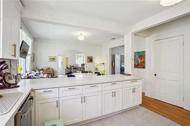 618-24 Fern St, New Orleans, LA 70118 - kitchen with arched walkways, dishwasher, light countertops, a peninsula, and white cabinets