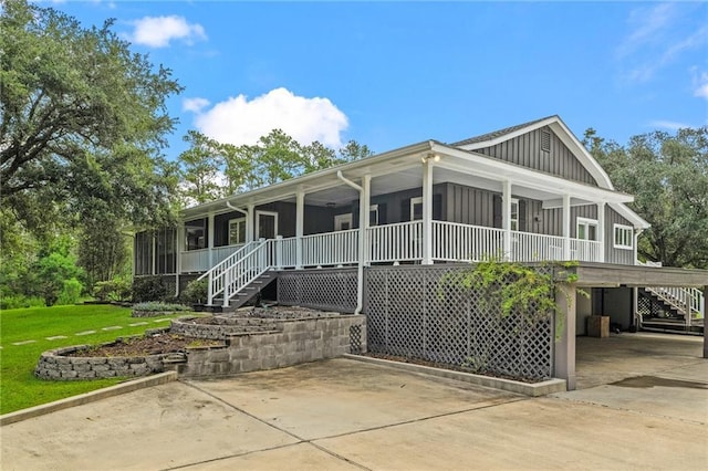 59246 Cypress Bayou Ln, Lacombe, LA 70445 - view of front of house featuring board and batten siding, stairway, a carport, concrete driveway, and a front yard