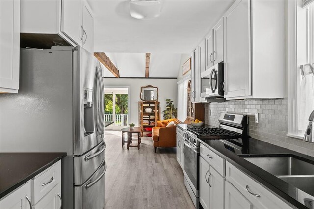 59246 Cypress Bayou Ln, Lacombe, LA 70445 - kitchen featuring stainless steel appliances, dark countertops, white cabinetry, tasteful backsplash, and light wood finished floors