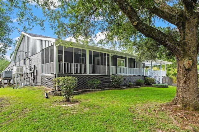59246 Cypress Bayou Ln, Lacombe, LA 70445 - rear view of property with a sunroom and a lawn