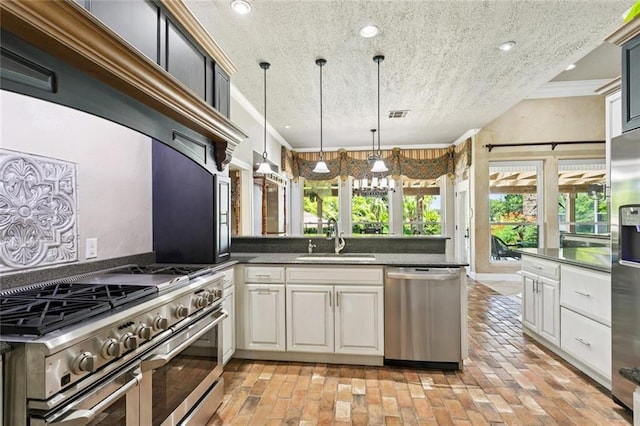 8 Oak Tree Dr, Slidell, LA 70458 - kitchen with stainless steel appliances, a textured ceiling, dark countertops, recessed lighting, and pendant lighting