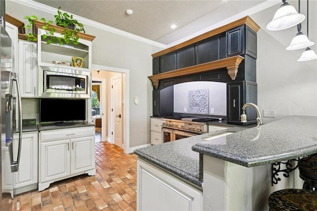 8 Oak Tree Dr, Slidell, LA 70458 - kitchen featuring appliances with stainless steel finishes, ornamental molding, a peninsula, brick floors, and dark stone countertops