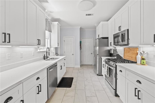 1107 Meadow Ct, Mandeville, LA 70448 - kitchen with stainless steel appliances, light marble finish floors, ornamental molding, white cabinetry, and light countertops