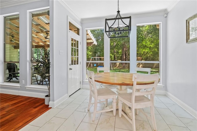 1107 Meadow Ct, Mandeville, LA 70448 - dining space featuring healthy amount of natural light, light marble finish floors, ornamental molding, and a chandelier