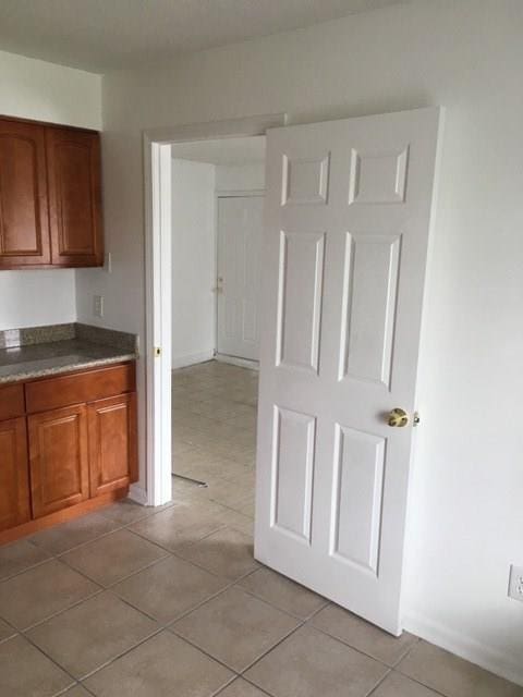 520 Emile Ave, Westwego, LA 70094 - kitchen with brown cabinets, light tile patterned floors, and dark countertops