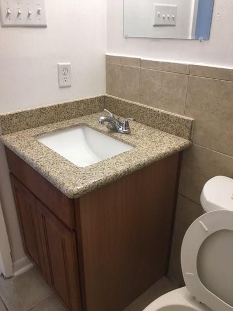 520 Emile Ave, Westwego, LA 70094 - half bathroom featuring vanity, tile walls, and tile patterned flooring