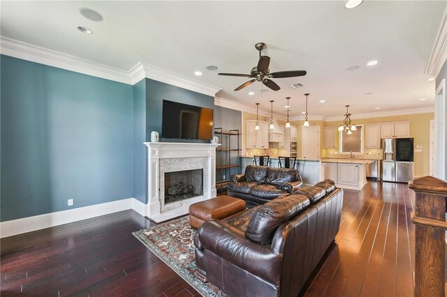230 26th St, New Orleans, LA 70124 - living area featuring a ceiling fan, a premium fireplace, dark wood-style floors, recessed lighting, and crown molding