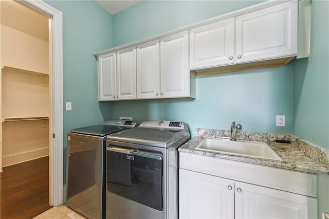 230 26th St, New Orleans, LA 70124 - washroom featuring washer and clothes dryer, cabinet space, and light wood-style flooring