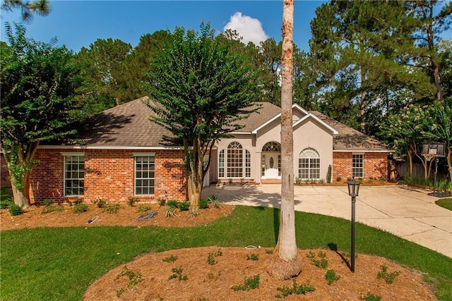 2212 Prairie Ct, Mandeville, LA 70448 - view of front of home with a front lawn, brick siding, and stucco siding