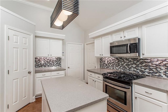 2212 Prairie Ct, Mandeville, LA 70448 - kitchen with stainless steel appliances, tasteful backsplash, white cabinetry, vaulted ceiling, and light countertops