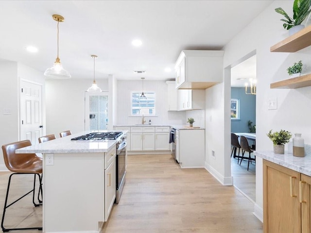 1340 Nursery Pl, Metairie, LA 70005 - kitchen with stainless steel gas stove, a breakfast bar area, light wood finished floors, open shelves, and recessed lighting