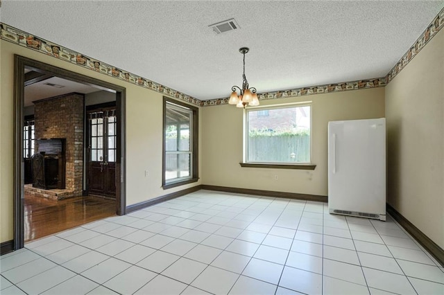 3541 Alan St, Metairie, LA 70002 - unfurnished dining area featuring a chandelier, a fireplace, and a textured ceiling