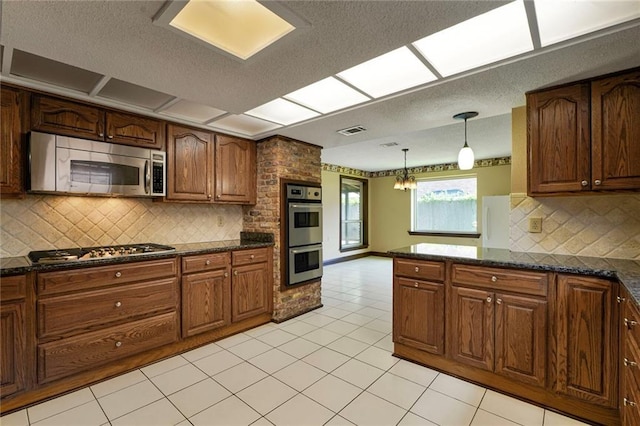 3541 Alan St, Metairie, LA 70002 - kitchen featuring stainless steel appliances, a textured ceiling, decorative light fixtures, tasteful backsplash, and light tile patterned flooring
