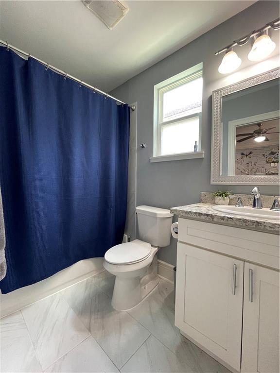 2272 N Robertson St, New Orleans, LA 70117 - bathroom with vanity, marble look tile flooring, and a shower with shower curtain