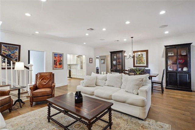 9 Hennessey Ct, River Ridge, LA 70123 - living room with crown molding, a chandelier, recessed lighting, light wood-style flooring, and stairway