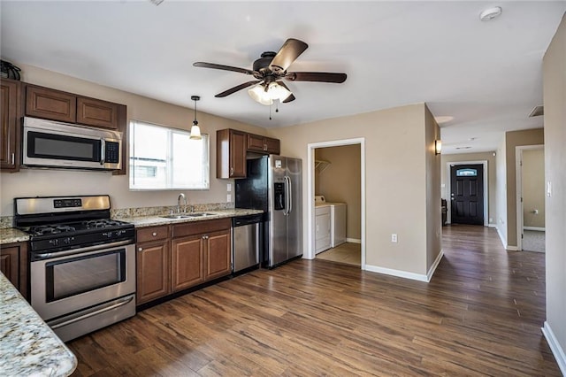 7922 Flounder St, New Orleans, LA 70126 - kitchen featuring stainless steel appliances, washer and clothes dryer, dark wood-style flooring, and a ceiling fan