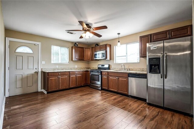 7922 Flounder St, New Orleans, LA 70126 - kitchen with appliances with stainless steel finishes, ceiling fan, dark wood finished floors, and decorative light fixtures