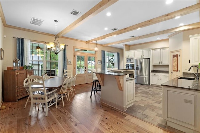 28 Hyacinth Dr, Covington, LA 70433 - kitchen with appliances with stainless steel finishes, french doors, beamed ceiling, a breakfast bar area, and crown molding