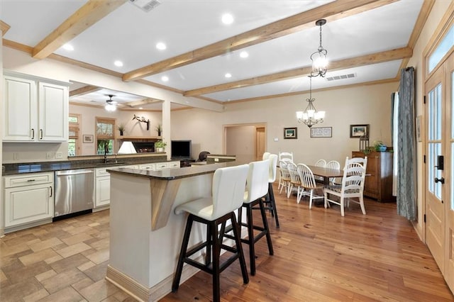 28 Hyacinth Dr, Covington, LA 70433 - kitchen with stainless steel dishwasher, dark countertops, beamed ceiling, plenty of natural light, and recessed lighting