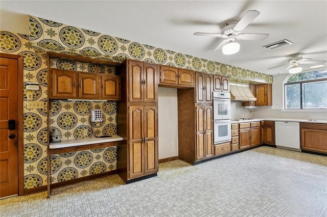 3709 Metairie Hts, Metairie, LA 70002 - kitchen featuring white appliances, light countertops, custom range hood, brown cabinetry, and ceiling fan