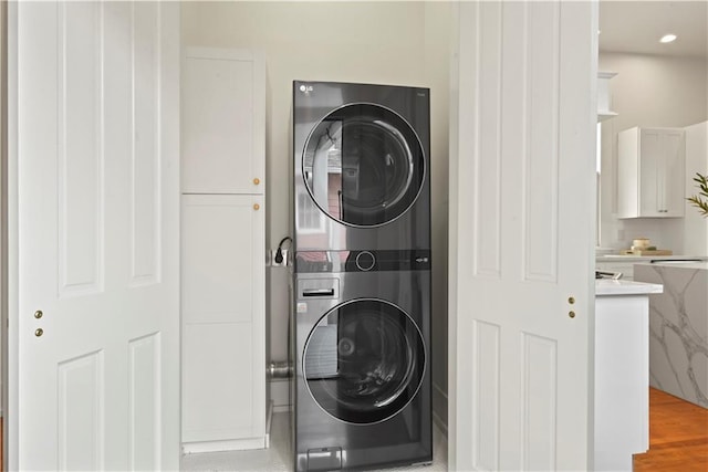 3311 Saint Ann St, New Orleans, LA 70119 - laundry area with stacked washer and clothes dryer, recessed lighting, and cabinet space