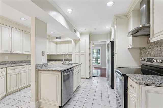 5033 Bissonet Dr, Metairie, LA 70003 - kitchen with wall chimney range hood, appliances with stainless steel finishes, light tile patterned floors, recessed lighting, and tasteful backsplash